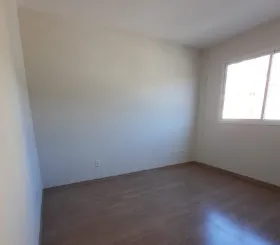 Quarto com piso laminado de madeira e janela no apartamento de 2 quartos