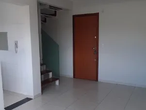 Entrada da cobertura com porta de madeira e escada para o segundo piso